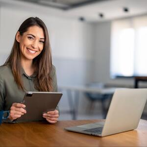 Woman smiling behind laptop